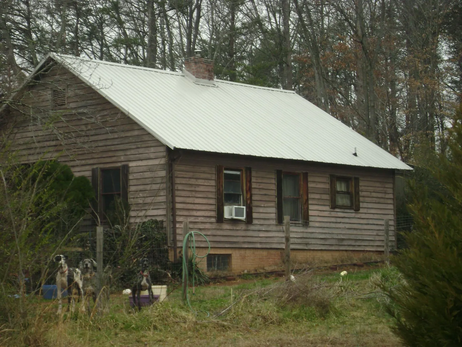 White metal roof on an old wood sided farmhouse, from a Metal Roof Installation job in Garrett